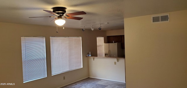 carpeted spare room featuring ceiling fan