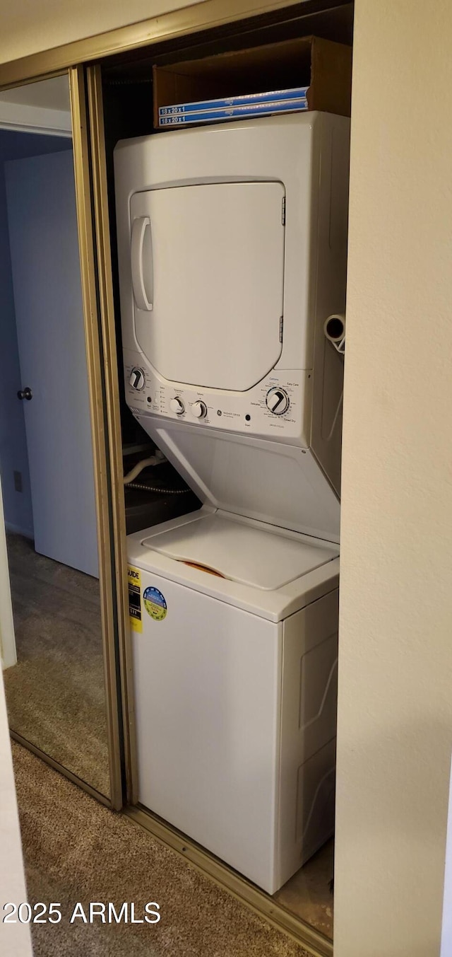 washroom with stacked washing maching and dryer