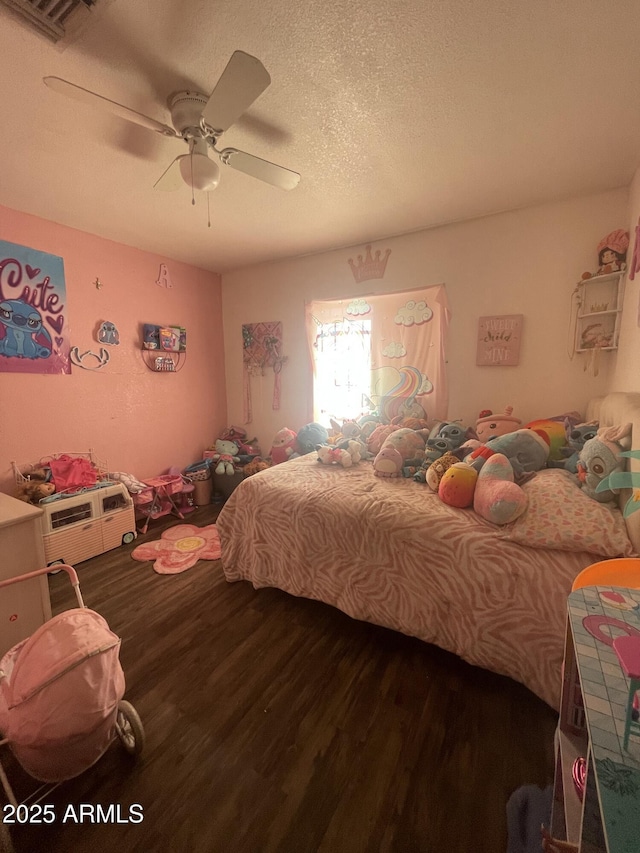 bedroom with hardwood / wood-style floors, a textured ceiling, and ceiling fan