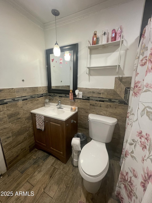 bathroom with tile walls, vanity, wood-type flooring, and toilet