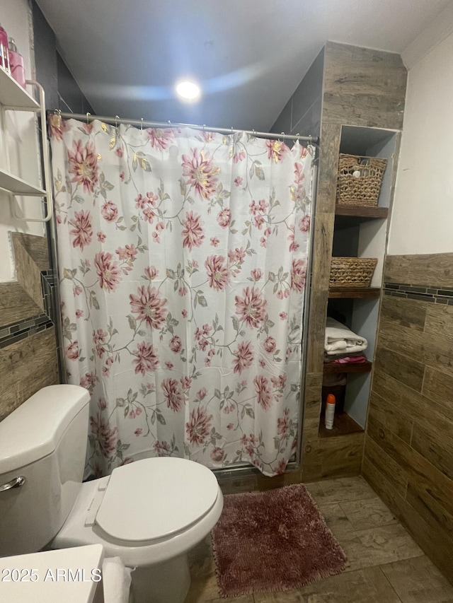 bathroom featuring toilet, tile walls, and a shower with shower curtain