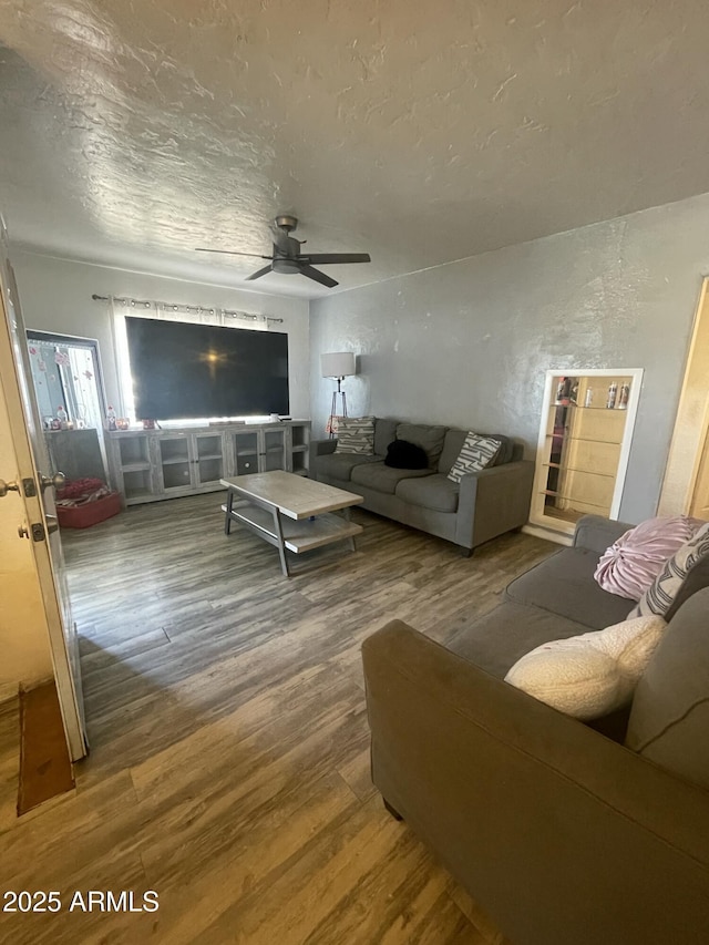 living room with hardwood / wood-style floors, a textured ceiling, and ceiling fan