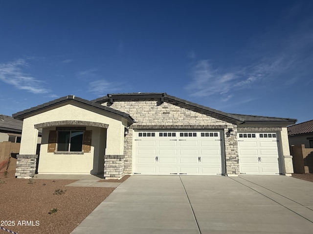 single story home with a garage, concrete driveway, stone siding, and stucco siding