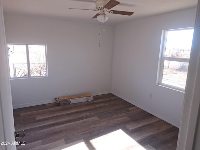 spare room featuring a ceiling fan, baseboards, and dark wood-style flooring