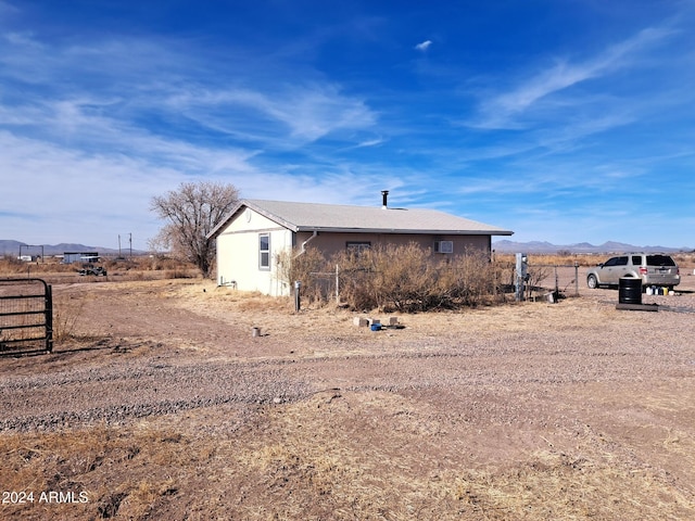 view of property exterior featuring fence and a mountain view