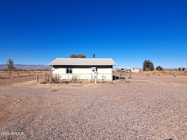 exterior space featuring a rural view, a mountain view, and fence