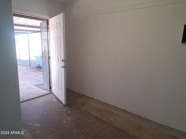 unfurnished room with concrete flooring