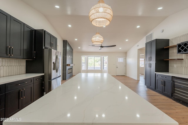 15038 E Greene Valley Dr, Fountain Hills, AZ 85268 - kitchen with beverage cooler, light wood-type flooring, stainless steel fridge with ice dispenser, and vaulted ceiling