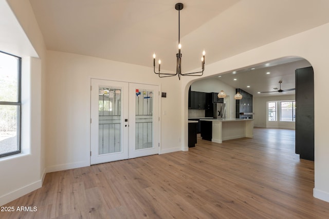 15038 E Greene Valley Dr, Fountain Hills, AZ 85268 - unfurnished living room with light wood-style floors, baseboards, ceiling fan with notable chandelier, and arched walkways