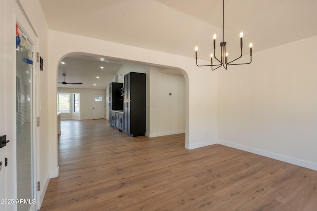 15038 E Greene Valley Dr, Fountain Hills, AZ 85268 - unfurnished dining area with baseboards, arched walkways, vaulted ceiling, wood finished floors, and a notable chandelier