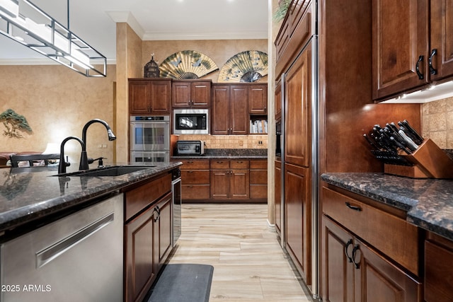 kitchen with stainless steel appliances, ornamental molding, a sink, and tasteful backsplash