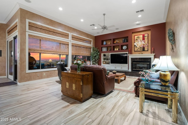 living area featuring visible vents, built in features, a high end fireplace, crown molding, and recessed lighting