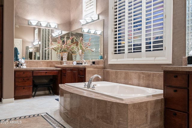 full bathroom with a garden tub, vanity, and tile patterned floors