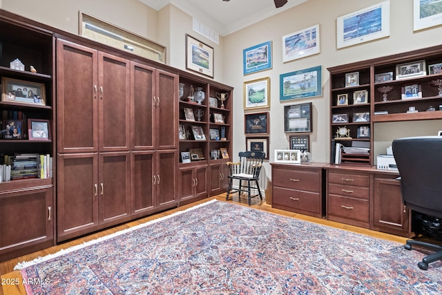 home office with light wood finished floors, ornamental molding, and a ceiling fan