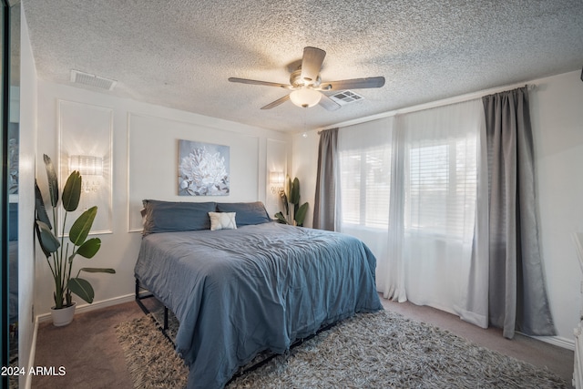 carpeted bedroom featuring a textured ceiling and ceiling fan