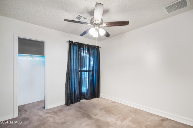 carpeted empty room with ceiling fan and a textured ceiling