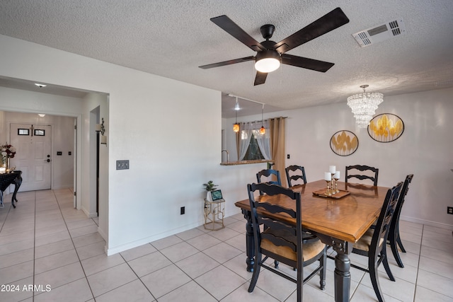 tiled dining room featuring a textured ceiling and ceiling fan with notable chandelier