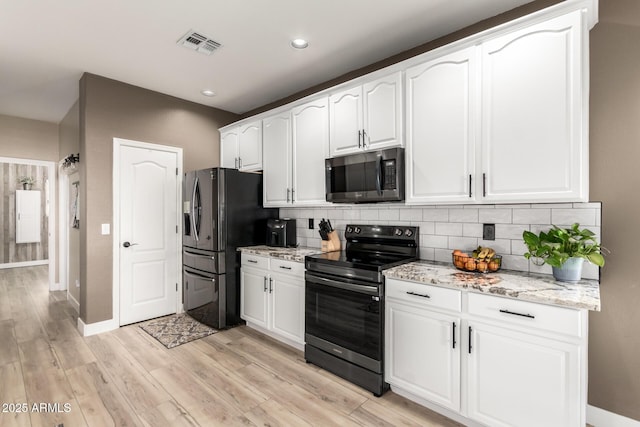 kitchen featuring range with electric stovetop, white cabinets, decorative backsplash, light stone countertops, and black refrigerator with ice dispenser