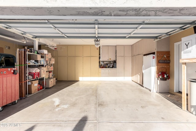 garage with a garage door opener and white fridge