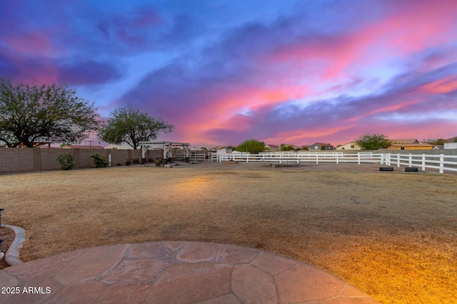 yard at dusk featuring a pergola