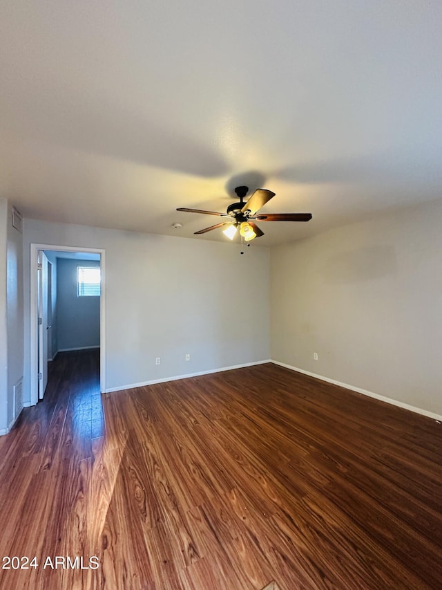 spare room with dark hardwood / wood-style floors and ceiling fan