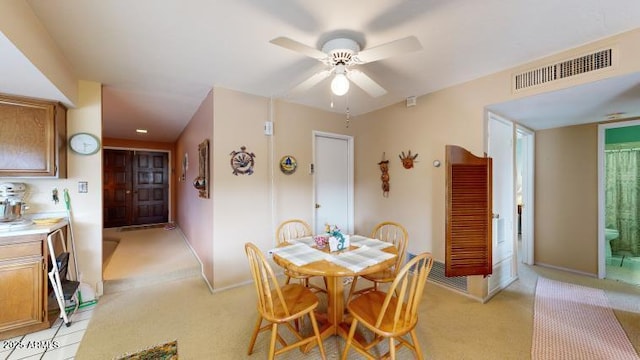 carpeted dining room featuring ceiling fan