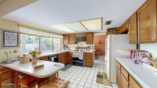 kitchen with a breakfast bar, light tile patterned floors, black dishwasher, white fridge, and electric stove