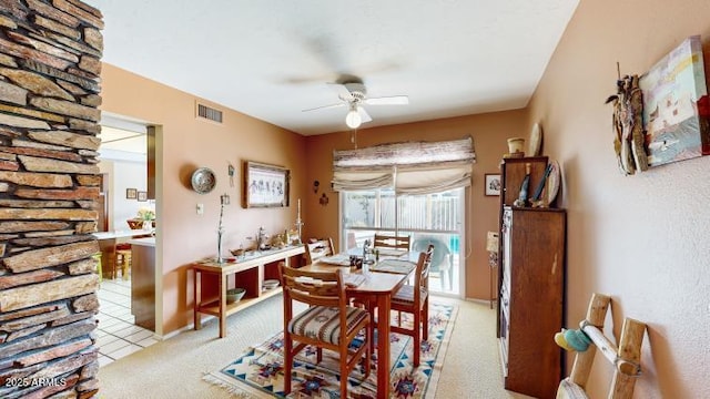 carpeted dining space with ceiling fan