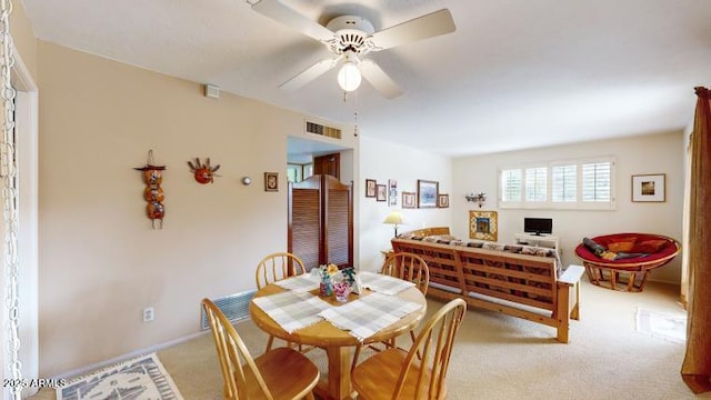 carpeted dining room featuring ceiling fan