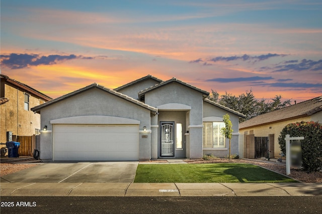 view of front of home with a garage and a lawn