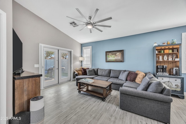 living room featuring ceiling fan, french doors, lofted ceiling, and light hardwood / wood-style flooring