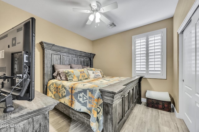 bedroom with ceiling fan, light hardwood / wood-style flooring, and a closet