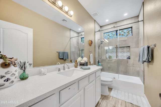 full bathroom featuring vanity, toilet, and bath / shower combo with glass door