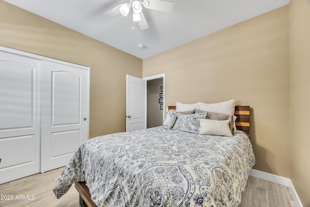 bedroom with ceiling fan, light wood-type flooring, and a closet