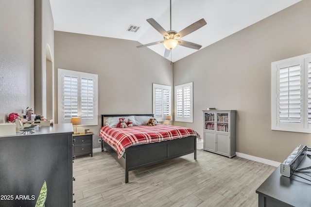 bedroom featuring multiple windows, ceiling fan, light hardwood / wood-style flooring, and lofted ceiling