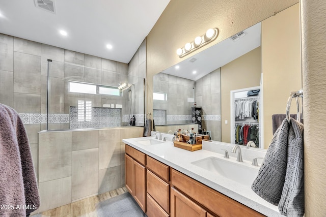 bathroom featuring tiled shower, hardwood / wood-style floors, and vanity