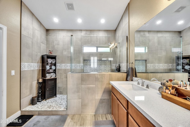 bathroom featuring a tile shower and vanity