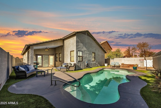 pool at dusk featuring a patio area, an outdoor living space, ceiling fan, and a grill