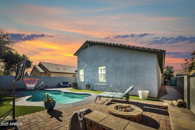 pool at dusk with a patio, a fire pit, and central air condition unit