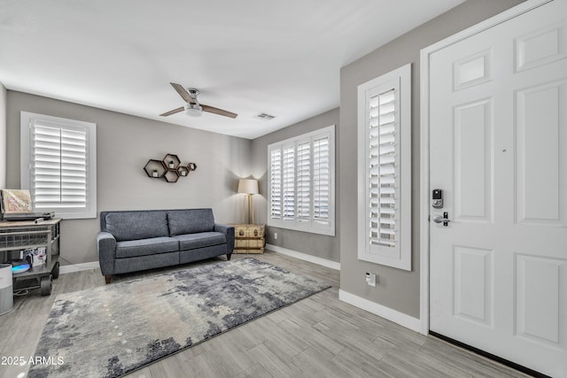 living room with ceiling fan and light hardwood / wood-style floors