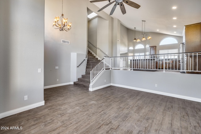 interior space featuring a towering ceiling, ceiling fan, and dark hardwood / wood-style flooring