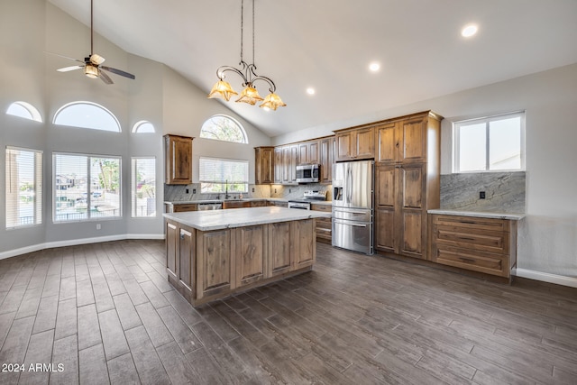 kitchen with backsplash, high vaulted ceiling, dark hardwood / wood-style floors, stainless steel appliances, and a center island