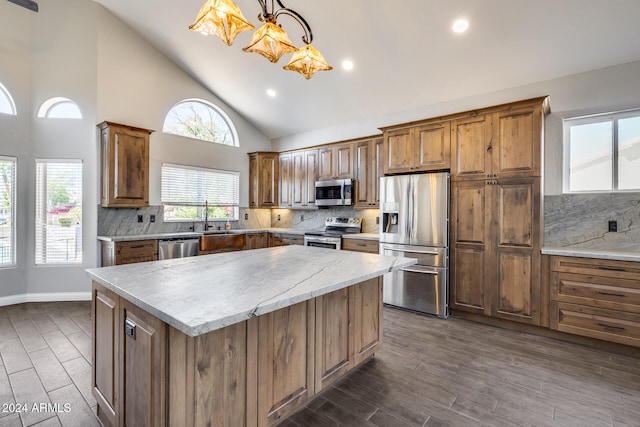 kitchen with tasteful backsplash, hanging light fixtures, stainless steel appliances, dark wood-type flooring, and high vaulted ceiling