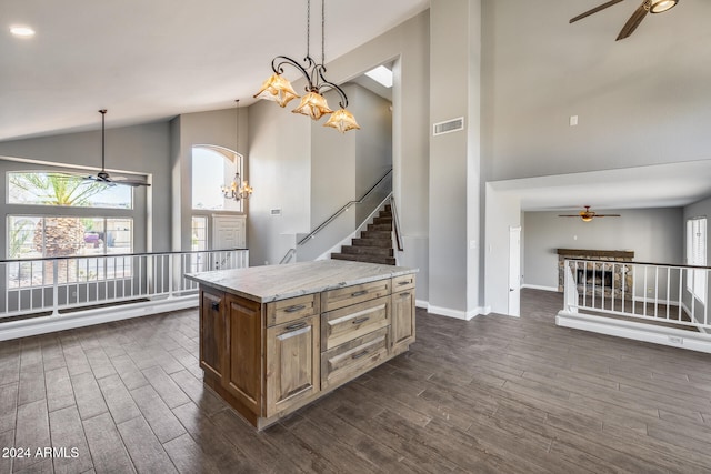 kitchen with an inviting chandelier, dark wood-type flooring, decorative light fixtures, and a kitchen island