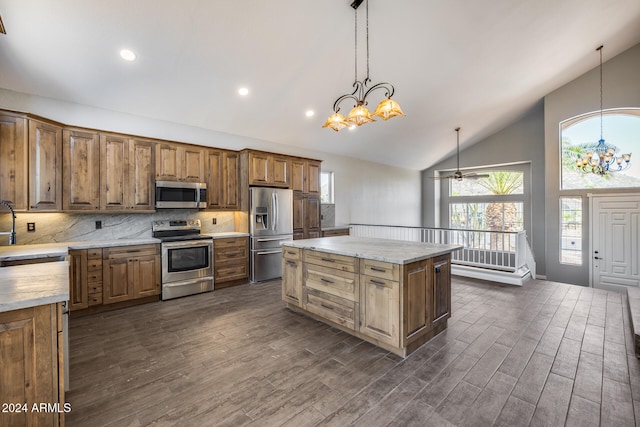 kitchen featuring decorative backsplash, a kitchen island, dark wood-type flooring, pendant lighting, and stainless steel appliances