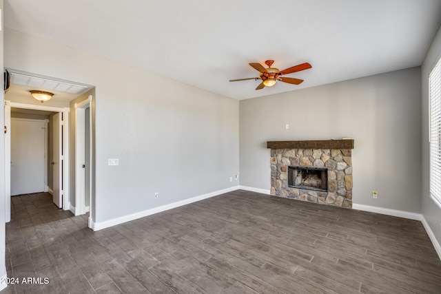 unfurnished living room featuring a fireplace, dark hardwood / wood-style floors, and ceiling fan