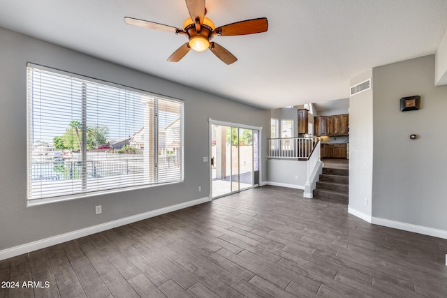 unfurnished living room with dark hardwood / wood-style floors and ceiling fan