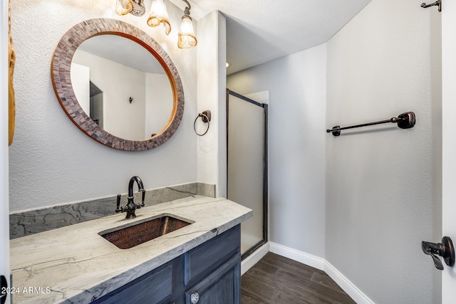 bathroom featuring a shower with door, vanity, and hardwood / wood-style flooring