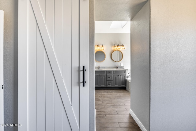 bathroom featuring vanity, hardwood / wood-style floors, and a skylight