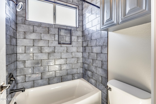 bathroom featuring toilet and tiled shower / bath